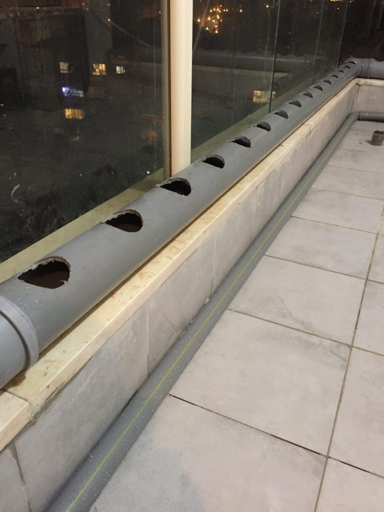 קדיחה בצינור PVC אפור של ביוב לשם הכנסת כוסות רשת